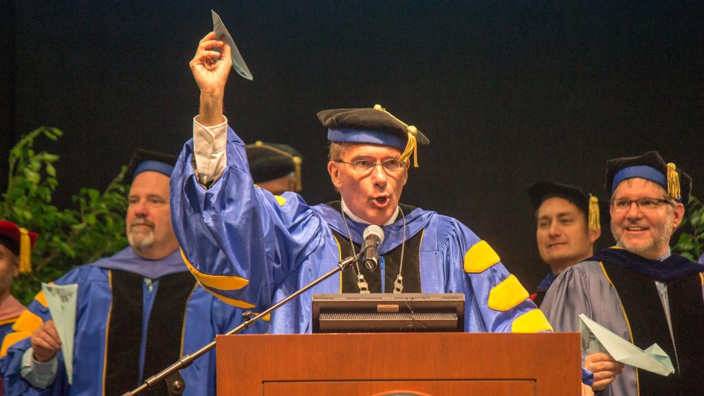 Ithaca College President Tom Rochon prepares to throw a paper airplane at Convocation Aug. 24. 