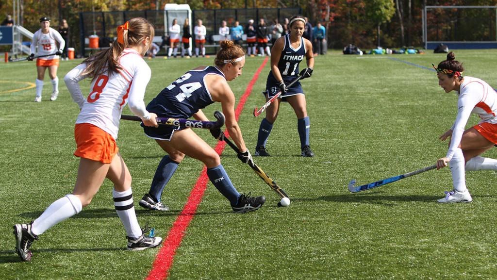 Junior defender Hannah Gerber dribbles the ball past two defenders during the teams match against Utica College on Oct. 11, 2014, at Higgins Stadium. 