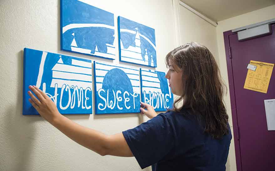 Sophomore Christy Calcagno hangs hand-painted posters in her room. She, like many Ithaca College students, places great importance on decorating her dorm.