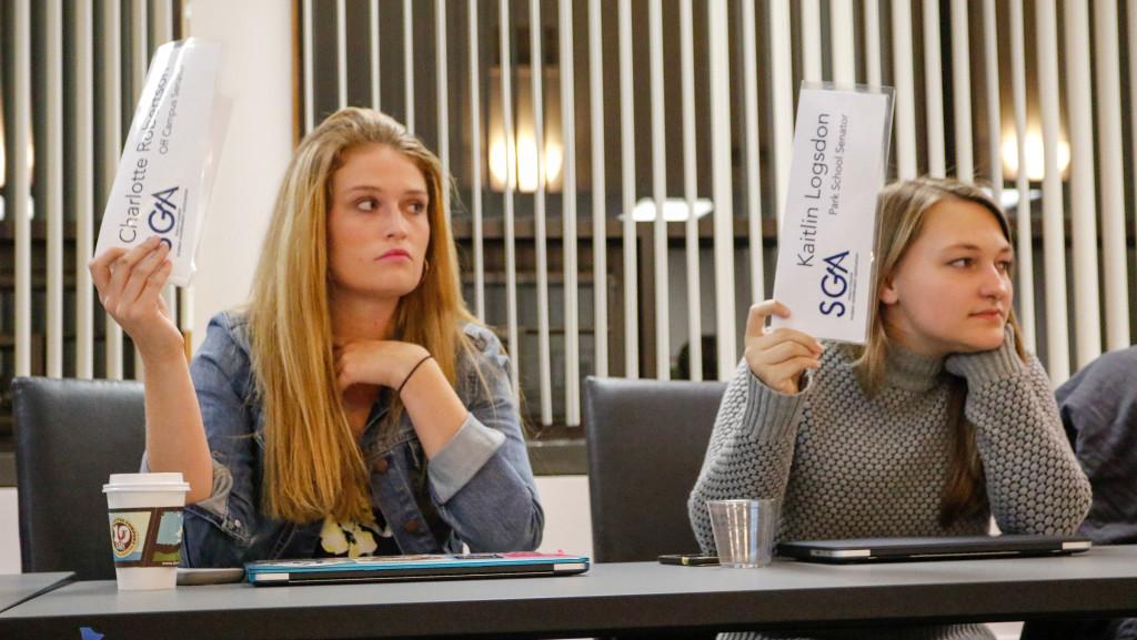 Student Government Association senators Charlotte Robertson and Kaitlin Logsdon vote at the Oct. 26 meeting. The senate passed a bill to initiate a student vote of no confidence in President Tom Rochon. The polls will open Nov. 4.