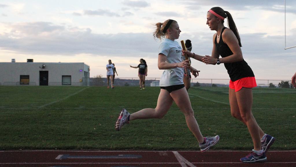 From left, freshman Britney Swarthout passes the baton to sophomore Sophia Feuer during a track and field practice Nov. 5 at Butterfield Stadium. 