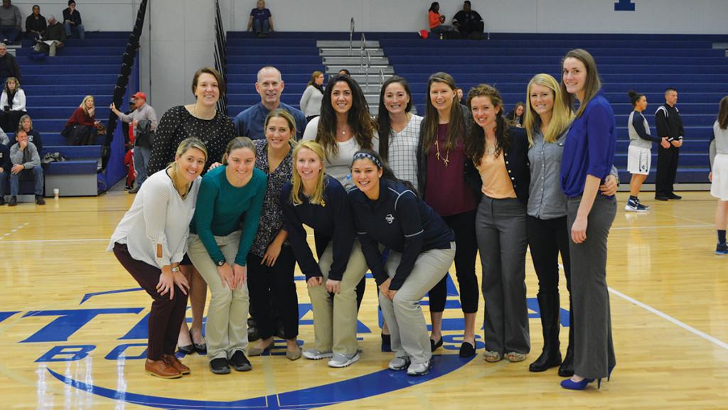 Head coach Dan Raymond of the women’s basketball squad poses with former players and current coaches for Coast Guard and Dickinson College on Nov. 21 in Ben Light Gymnasium.