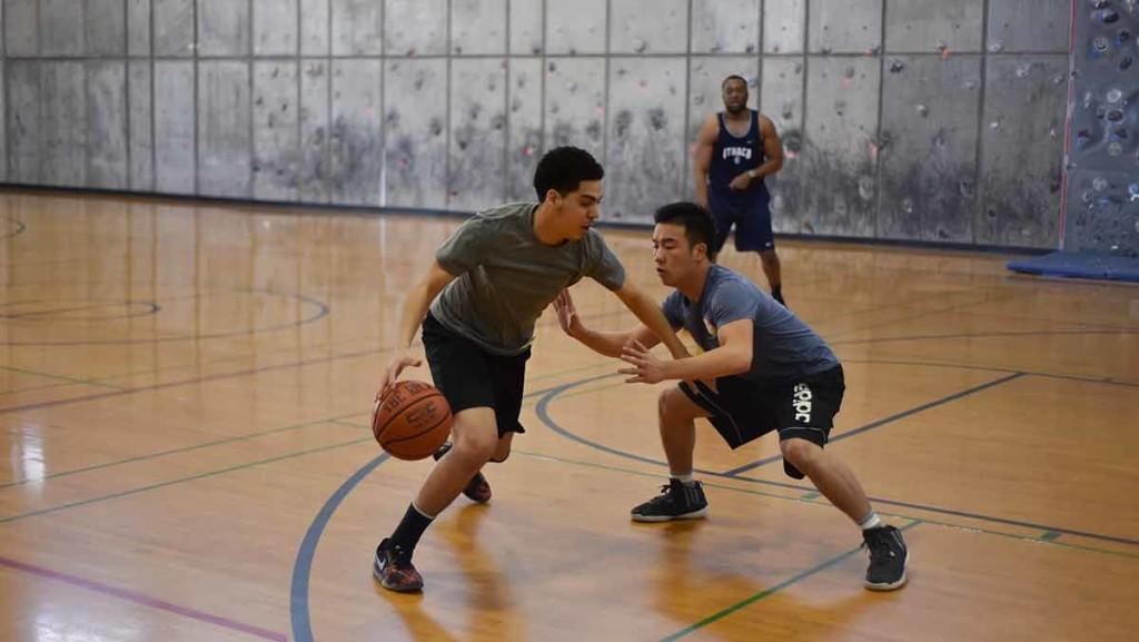 Sophomore Daniel Nunez challenges his defender, freshman Tony Luo, during the three vs. three basketball tournament hosted by Brothers 4 Brothers and the Ithaca College Asian American Alliance in the Fitness Center. A total of $240 was raised during the event.