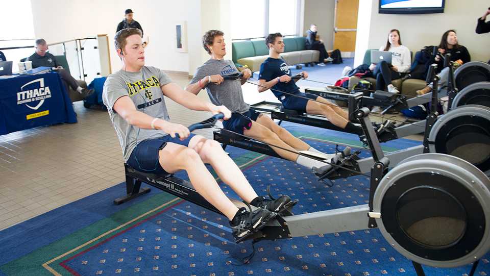 Members of the crew team ride stationary rowing machines during the squads annual Row for Humanity event Feb. 5 in the north foyer in Campus Center. In the 12-year history of the event, the Bombers have raised over $60,000 for Habitat for Humanity. 