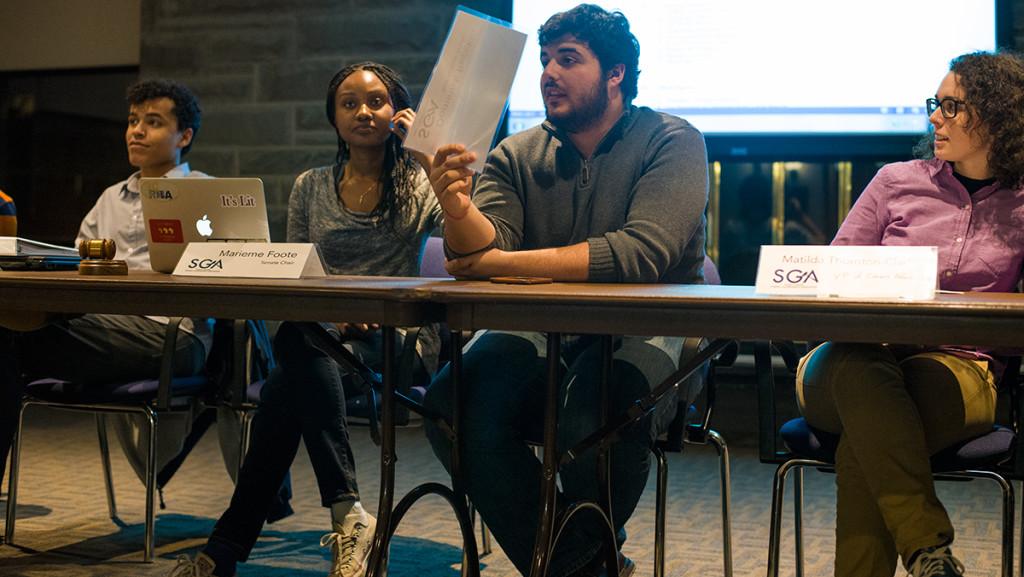 From left, Evan Layne, vice president of business and finance; Senate Chair Marieme Foote; Dominick Reckkio, Student Government Association president; Matilda Thornton-Clark, interim vice president of campus affairs raise placards to speak during the Feb. 1 SGA meeting.