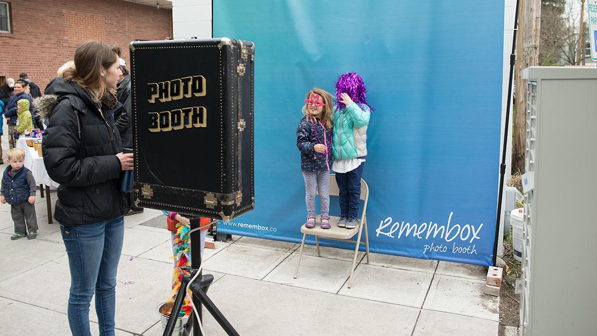 Two young girls who attended the Climate Solutions Fair dressed up and posed together in front of a makeshift photo booth located at the Press Bay Alley event April 23.