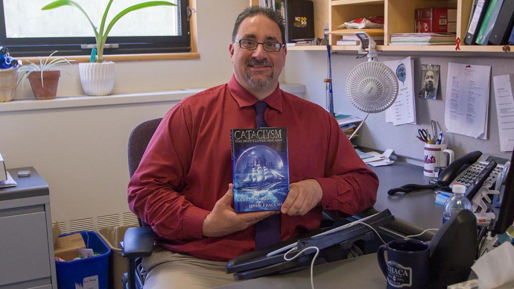 John Fracchia, associate director of the Office of Career Services at Ithaca College, holds a copy of “Cataclysm: The Myst Clipper Shicaine,” a science-fiction novel released May 4. 