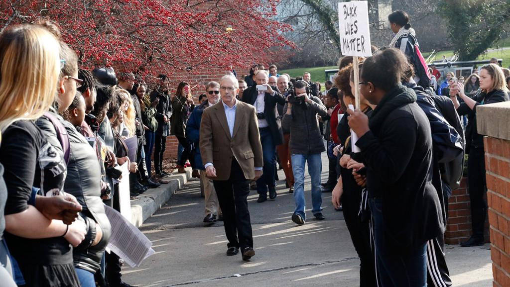 Ithaca College students make way for President Tom Rochon at the Dec. 11 protests where protesters called for his resignation. Experts, faculty and students say the protests leading to the presidents resignation could affect the applicant pool for the college’s ninth president.
