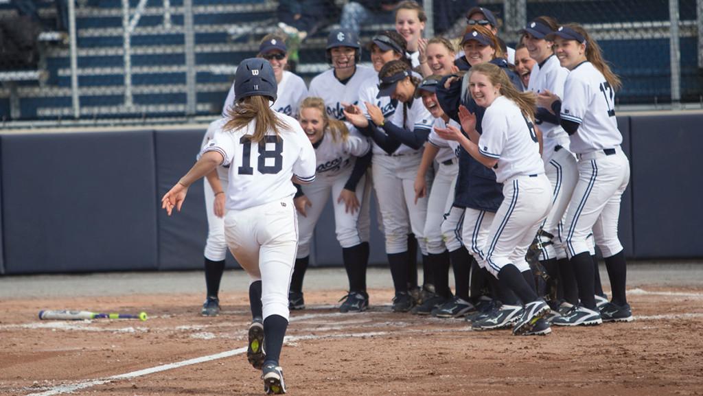 Members of the softball team celebrate freshman Vanesssa Brown’s walkoff home-run March 30 against the University of Rochester at Kostrinsky field. The Bombers won 10–4.
