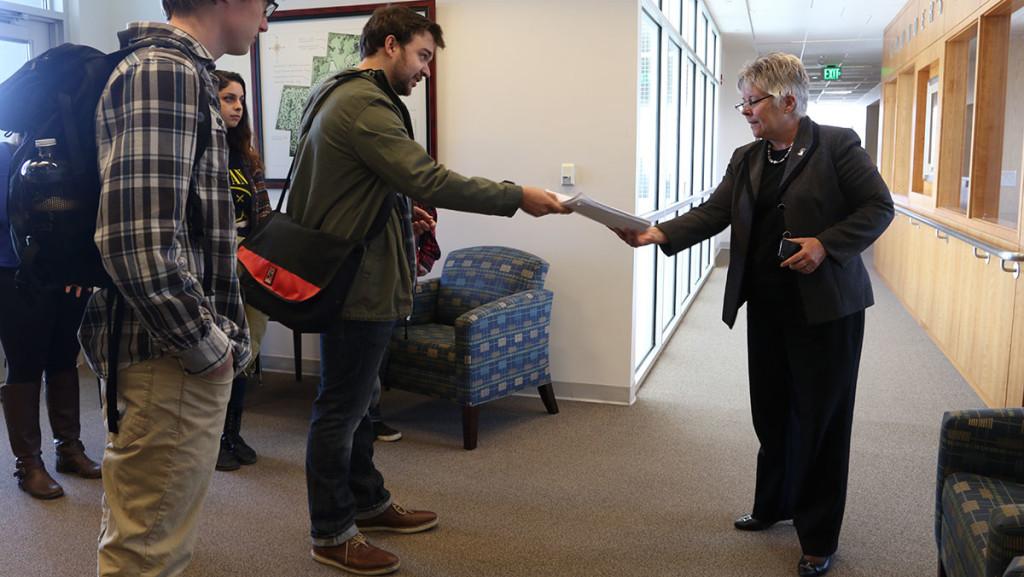Junior Taylor Ford, accompanied by Sophomore Talia Sklonik and Junior Peter Zibinski, hand Nancy Pringle, senior vice president and general counsel for the Division of Human and Legal Resources, a petition with 468 signatures from the campus community, showing their support for part and full-time contingent faculty unionization on April 27.  