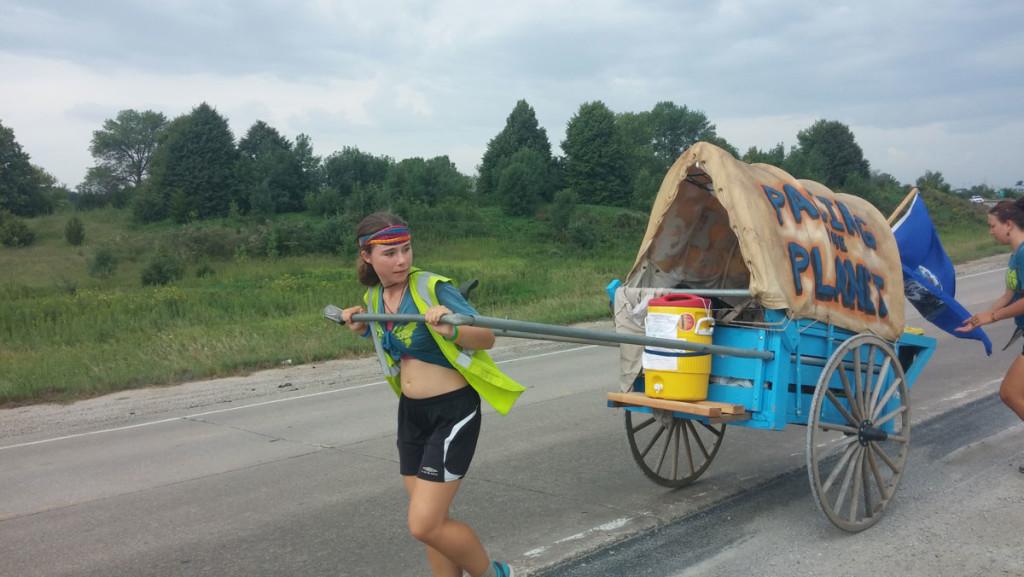 Junior Faith Meckley pulls a Conestoga-style wagon near Branchport, Iowa, in August 2014 as part of the cross-country Great March for Climate Action, for which she took a semester off college.