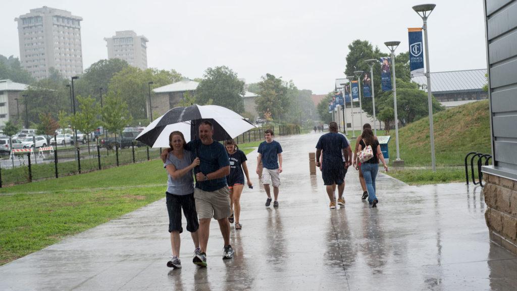 Students and their families run from the rain while checking in at the Athletics and Events center for move-in day Aug. 21.

Jade Cardichon/The Ithacan