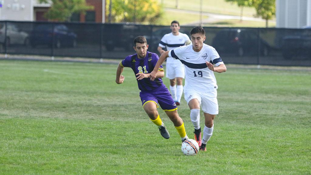 Freshman Justinian Michaels looks for a pass after beating a Nazareth College defender in the Bombers game Sept. 24 on Carp Wood Field. The Bombers won 1–0.