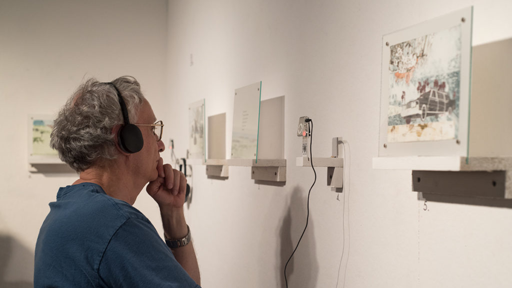 A local Ithaca resident listens to musician Billy Coté’s musical contribution to “36 Transitions,” which is the new exhibition at the Ink Shop in downtown Ithaca and will remain open until Oct. 29.