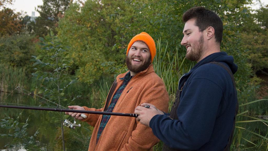 From left, senior Cole Handerhan, co-founder and vice president of the Anglers Club, and senior Kurt Hoefig laugh while catching fish on the pond next to Muller Chapel on Oct. 10.