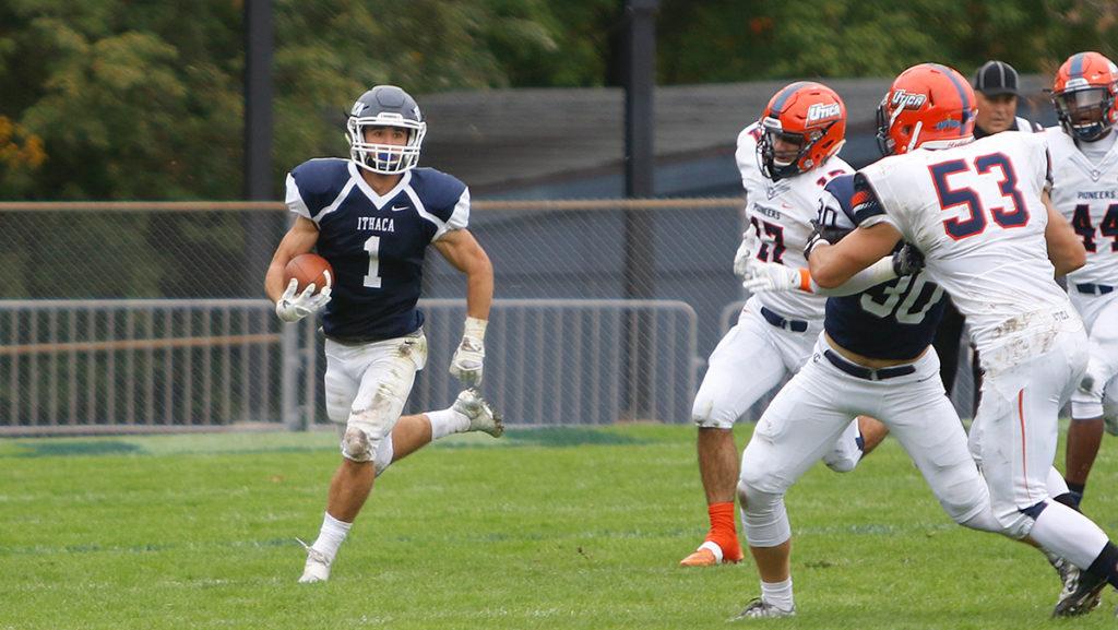 Junior cornerback Jordan Schemm receives the ball from senior quarterback Wolfgang Schafer and runs in an open lane in the Bombers game against Utica College on Oct. 1 at Butterfield Stadium.