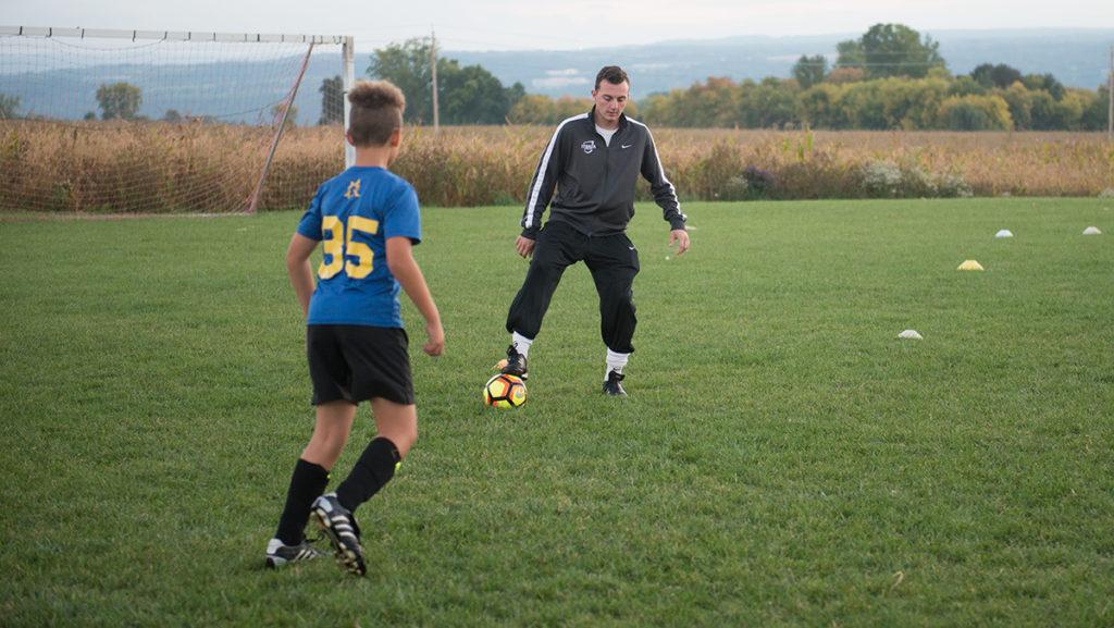 Junior Nicholas Gualtieri coaches the TC Waza Academy on Oct. 4 in Lansing, New York. He began teaching the kids, who range in ages from 4 to 19, four years ago. 