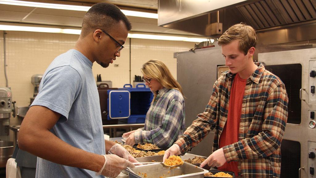 From left; junior Christian Conyers, sophomore Michaela Koetzner and sophomore Andrew Kenney package food for SWIFT. 