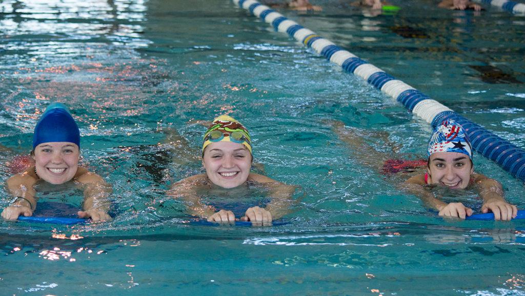 From left, sophomore Abby Miller and freshmen Maddie Lowe and Brooklyn Saliba kick during the swim-a-thin Nov. 13 in the Athletics and Events Center. 