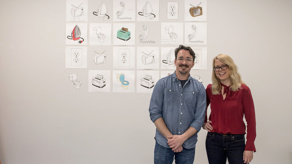 Assistant professors Bill Hastings and Sarah Sutton stand beside “Overload,” the latest experiemental exhibit from senior Geneva Bielenberg. The duo are integrating the work of their students into the relocated space.