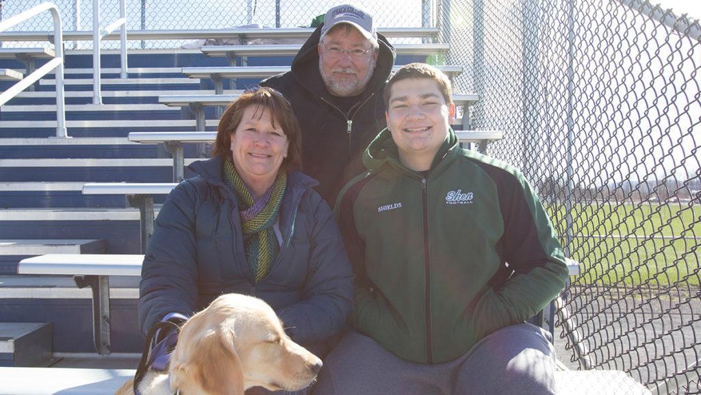 Lori and Gary Shields, their son, Michael, and dog Russell, travel from Clifton Park to watch their daughter, freshman Abby Shields, play softball.