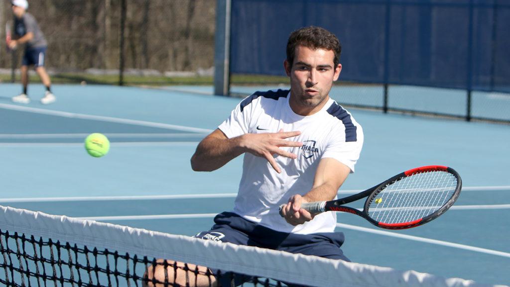 Junior Lorenzo Viguie-Ramos ready to hit the ball over the net during his doubles match with teammate senior Wes Davis April 14 against St. John Fisher College.