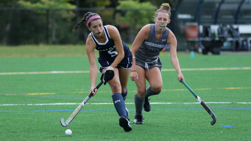 Senior midfielder Amanda Schell looks to pass the ball to a teammate while trying to get passed sophomore defender Kortney McEwen of Misericordia University. The Bombers won the game in overtime 3–2.