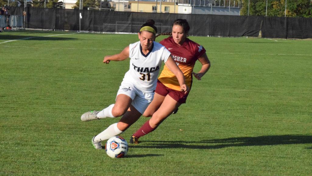 Sophomore forward Ally Christman looks to kick the ball before freshman midfielder Shiane Irwin of St. John Fisher catches up to her. The Bombers shut out the Cardinals 4–0 at Carp Wood Field.