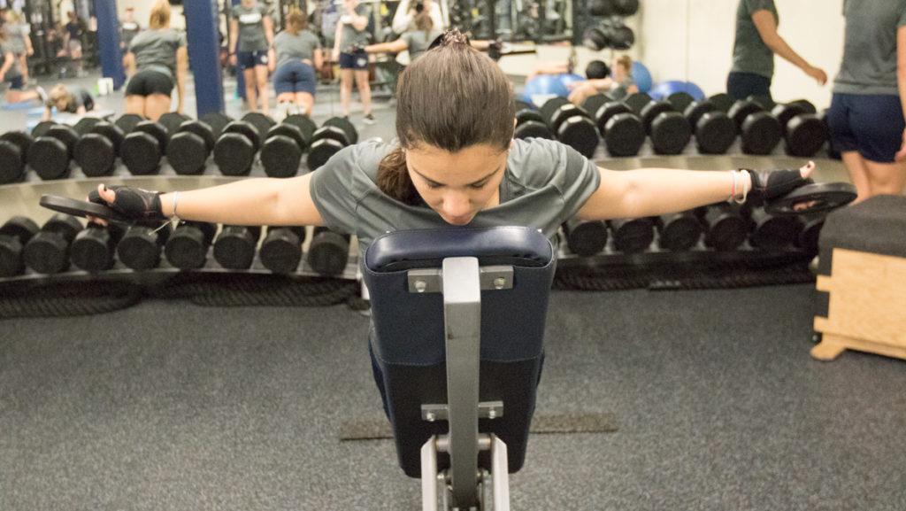 Senior freestyle swimmer Nilza Costa uses weights as part of her circuit during  conditioning practice at 6:20 a.m. in the Athletics and Events Center weight room.