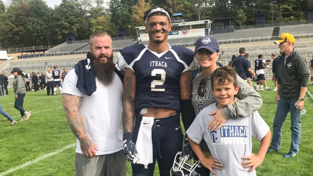 From left, Marc Brainard, sophomore wide receiver Will Gladney, Jennifer Gates and her son, Kingston Brainard at Gladneys game against Hobart College on Sept. 30. Brainard and Gates adopted Gladney his sophomore year of high school.