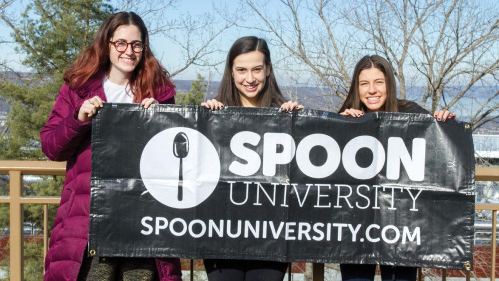 Sophomores Unagh Frank, Mia Reingold and Brianna Ruback hold up the Spoon University sign. They are all members of the college's chapter, which gives college students the tools to write, photograph, create videos and host events focused on food.