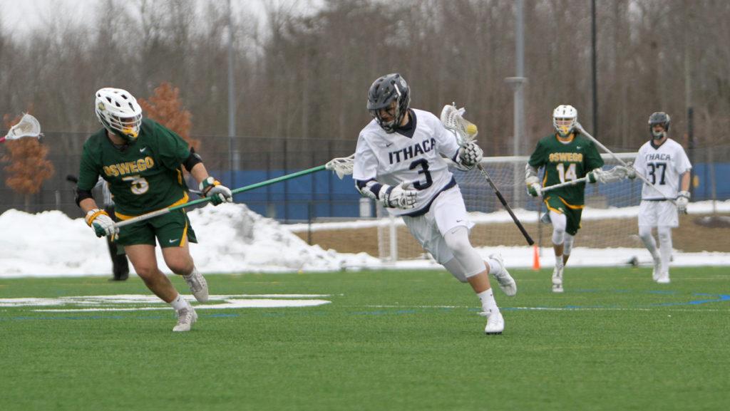 Sophomore attack Ryan Ozsvath cradles the ball against John Petrelli, SUNY Oswego sophomore defenseman during the Bombers 14–5 win over the Lakers on March 7 at Higgins Stadium.