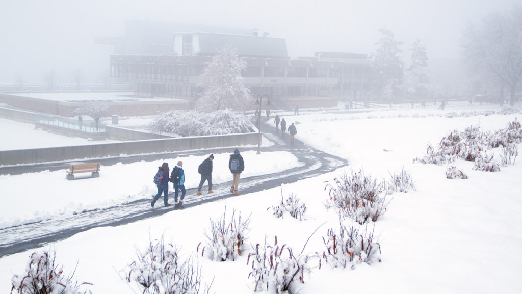 Students walk from classes through the snow in February. Approximately 6–12 inches of snow are expected from Dec. 1 at 7 a.m. to Dec. 3 at midnight, according to the National Weather Service.
