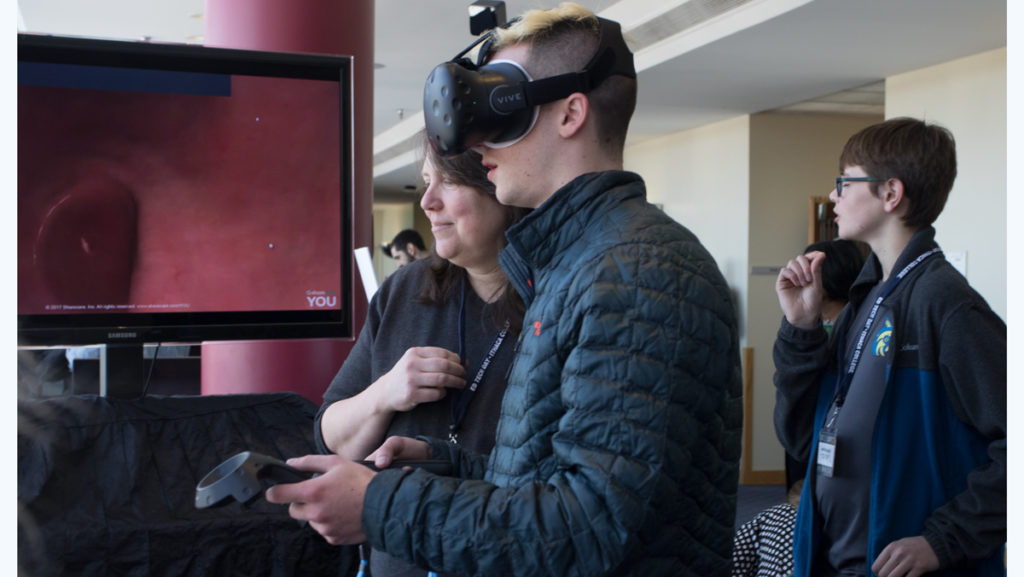  Junior Jack Lewis engages with a vendor’s virtual technology simulation at this year’s 28th annual Educational Technology Day at Ithaca College on March 22 in Campus Center. The regional technology event attracts over 1,600 people and vendors.  		 