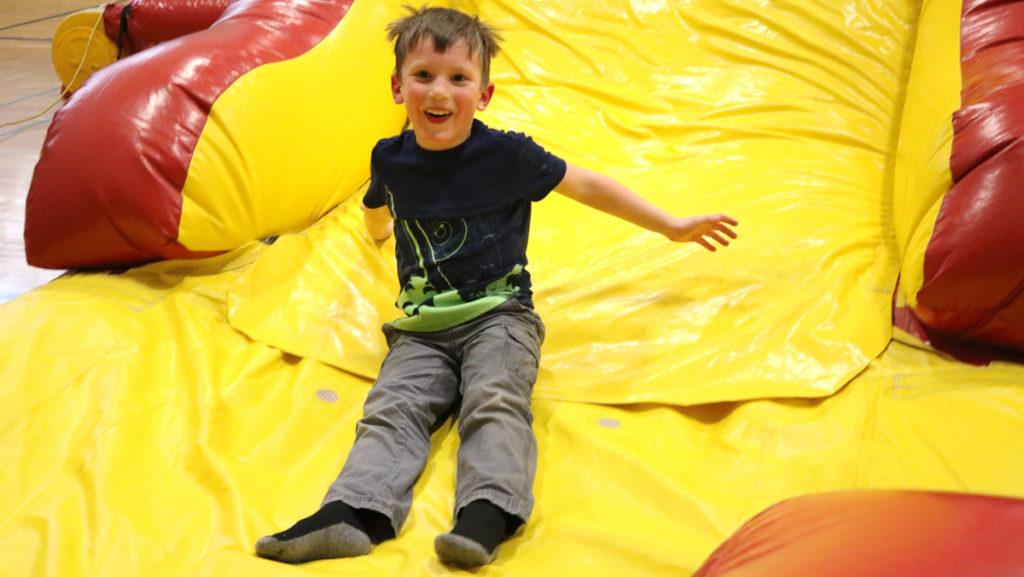 Josiah Swiller, 5, plays on the bouncy house slide at the Family Carnival on April 6. The Family Carnival was hosted by the Ithaca College Student United Way to raise money for local nonprofits in the Fitness Center.