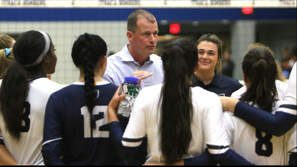 Head coach Johan Dulfer huddles with the team during the Bomber Invitational on Aug. 31 in Ben Light Gymnasium.