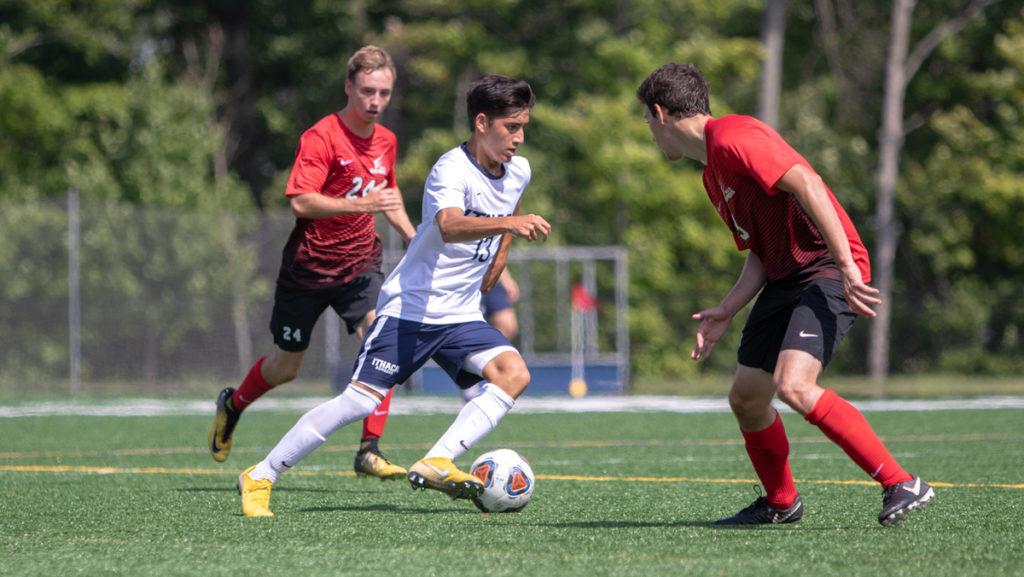 Freshman midfielder Alex Leahy cuts between two Wells College defenders on Sept. 7. The Bombers won the match 2–1 in overtime, and have played five overtime games so far this season, with a record of 2–0–3