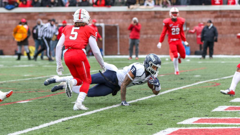Junior wide receiver Will Gladney dives into the endzone for a touchdown while Max Jean, Cortland senior defensive back, tries to stop him. The Bombers defeated SUNY Cortland 24–21.