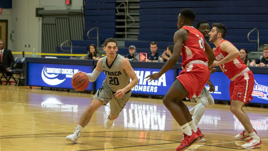 Sophomore guard Cooper Macklin drives to the basket against Cortland junior forward Kenny Charles during the Bombers' 85–75 loss Nov. 27.