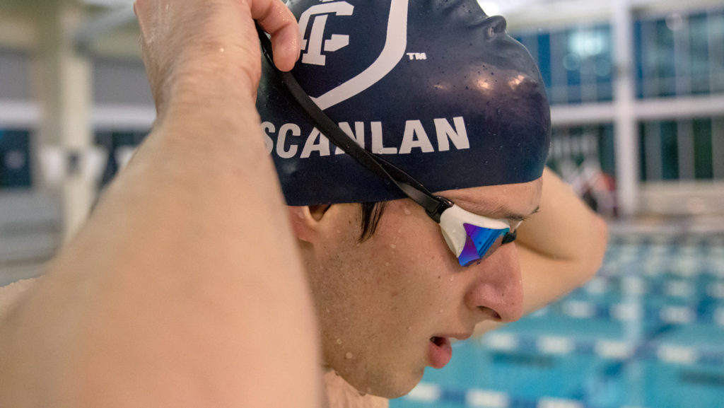 Senior swimmer Kellen Scanlan adjusts his goggles during a swim meet at the Kelsey Partridge Bird Natatorium. Scanlan is a team captain and one of four seniors on the roster. 