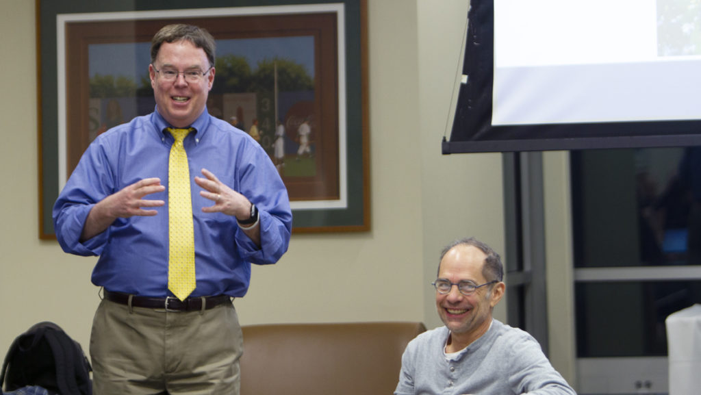 Dave Prunty (left) and Tom Swenson (sitting down) discussed Ithaca College’s commencement at the Faculty Council meeting on Feb. 5. Possible campus-wide policies on technology were also deliberated. 