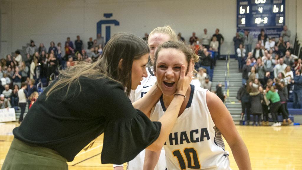 Senior guard Annie Giannone is congratulated by assistant coach Mary Kate Tierny 14 after sinking a game-tying buzzer-beater from half court. The Bombers went on to win the game 72–66.