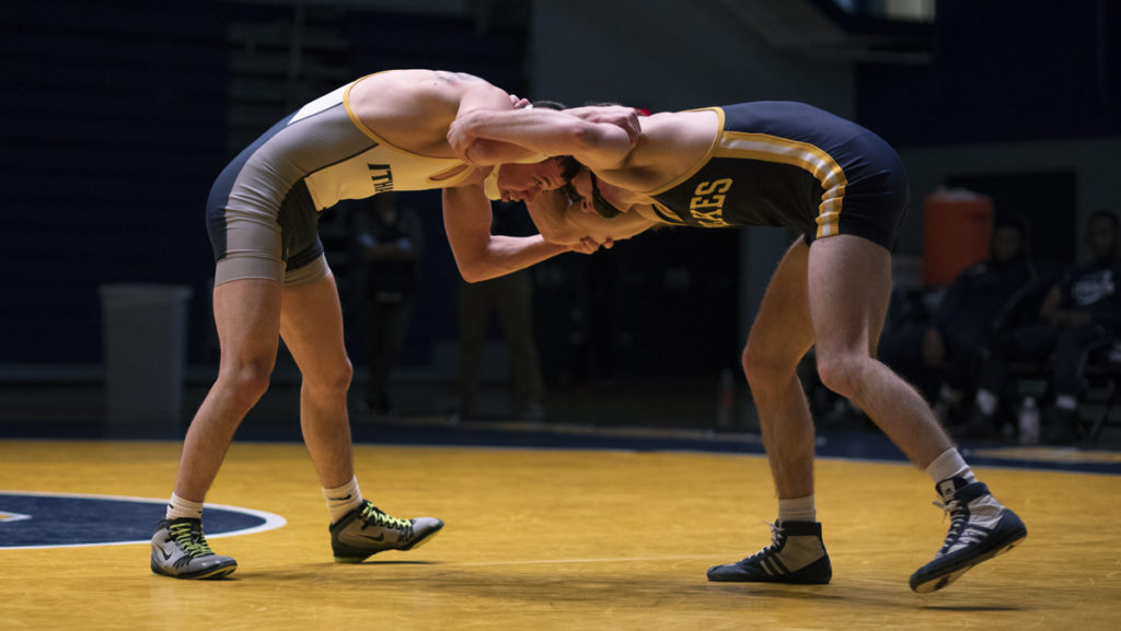 Junior Tito Colom faces off against Wilkes University sophomore Dylan OConnor during a meet on Feb. 8 in Ben Light Gymnasium. Colom won the match 13–4. 