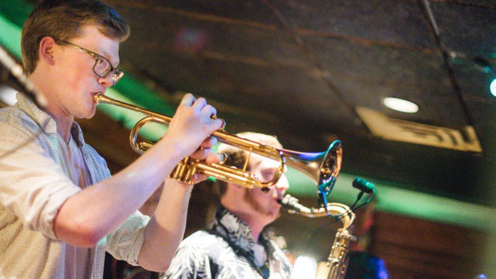 From left, junior Dan Yapp plays the trumpet while performing in his band, Butter, for its EP release show Feb. 16 at Sacred Root Kava Lounge and Tea Bar. The band plays funk music and is composed of current Ithaca College students and alumni.