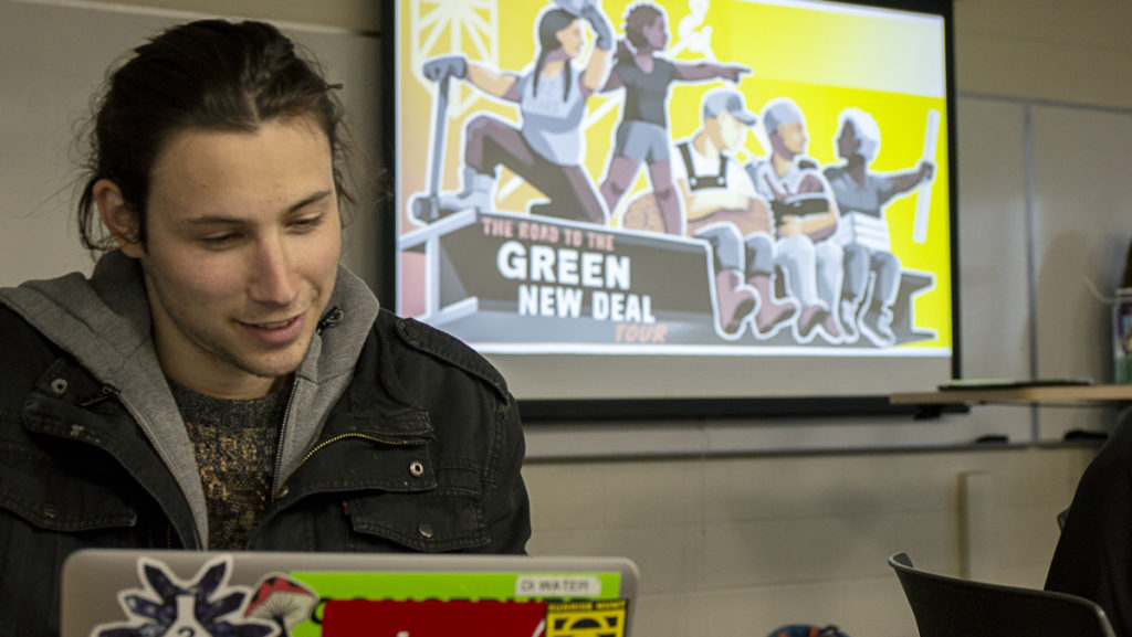 Senior Alex Mora reads part of the Green New Deal during a Sunrise Movement town hall planning meeting April 2. The Sunrise Movement is a nationwide climate activism campaign that was recently brought to campus.
