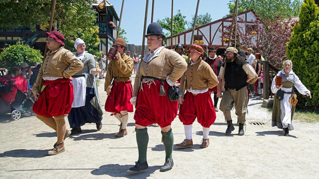 Third from left, sophomore Daniel Igoe marches at The Bristol Renaissance Faire in Bristol, Wisconsin, with a group of other costume-clad workers. Igoe began working with the fair two years ago and said he found a community through it.  