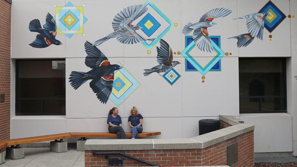 Seven red-winged blackbirds soar across the back of Egbert Hall, near the Free Speech Rock. The mural was painted by Nani Chacon, who worked to make the mural compliment the student body and its important location.