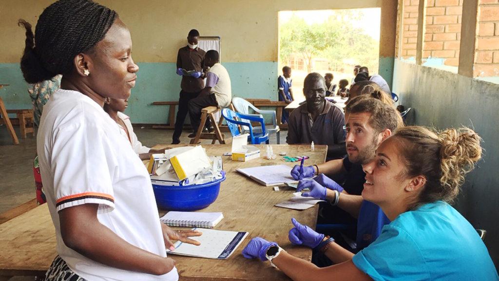 From left, Cathy Kapondo Thom, nurse in charge of the mobile medical clinics, speaks with physical therapy students Luke Charles and Kendall Cirella. They tested patients for malaria. 