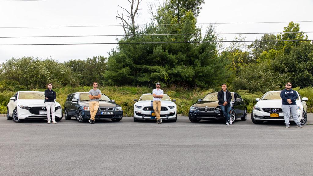 From left, Car Club members freshman Maxwell Rosenblatt, junior Aaron Segal, senior Derran Smith, junior Rob Korfhage and sophomore Alex Koffman stand with cars owned by the members. The club recently added Vashane Rhooms 18 as its adviser. 