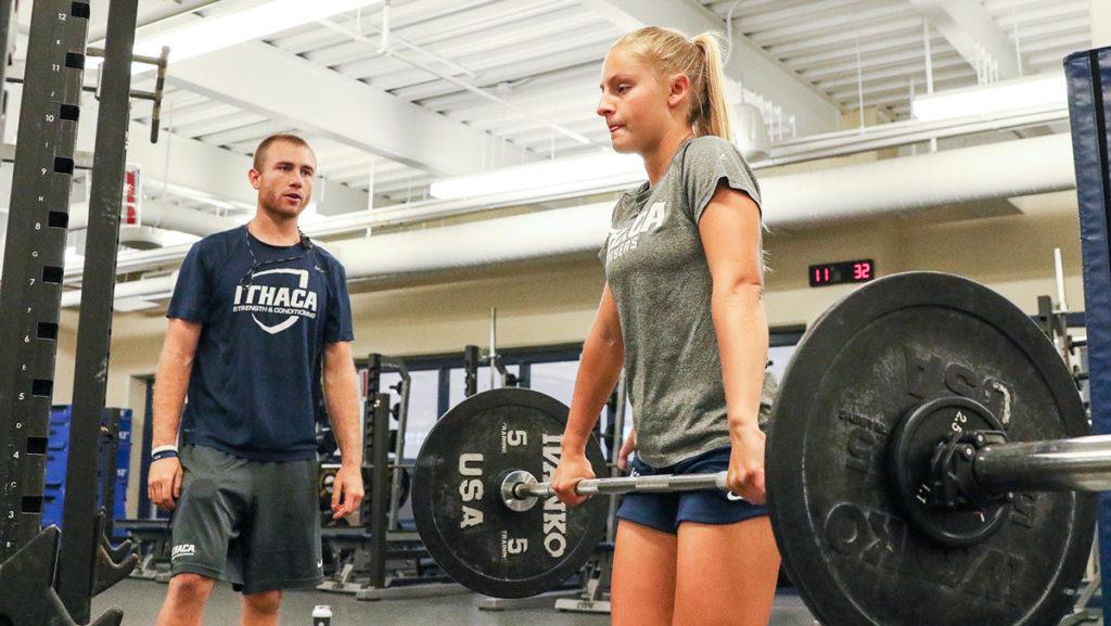 From left, Dakota Brovero, a graduate student assistant strength and conditioning coach, observes the form of Morgan Mullen, sophomore field hockey striker, as she completes an exercise. 